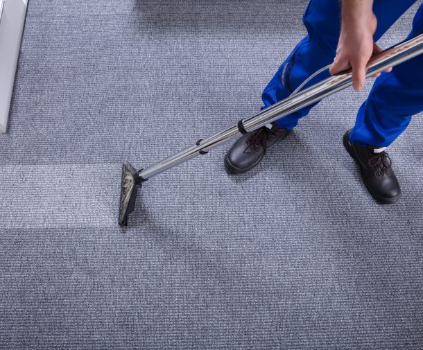 Janitor's Hand Cleaning Carpet With Vacuum Cleaner