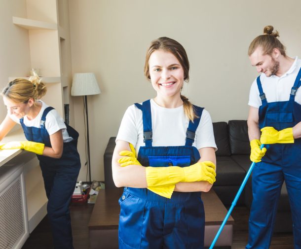 Cleaning service with professional equipment during work. professional kitchenette cleaning, sofa dry cleaning, window and floor washing. man and women in uniform, overalls and rubber gloves